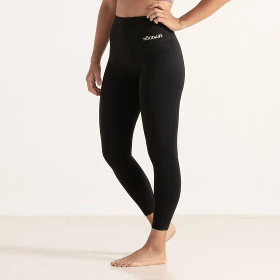 Legging negro de cintura alta, de cintura para abajo y descalza.
