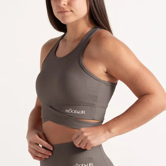 Top gris de canalé con una banda cruzada bajo el pecho y el logo bordado, con legging a juego.
