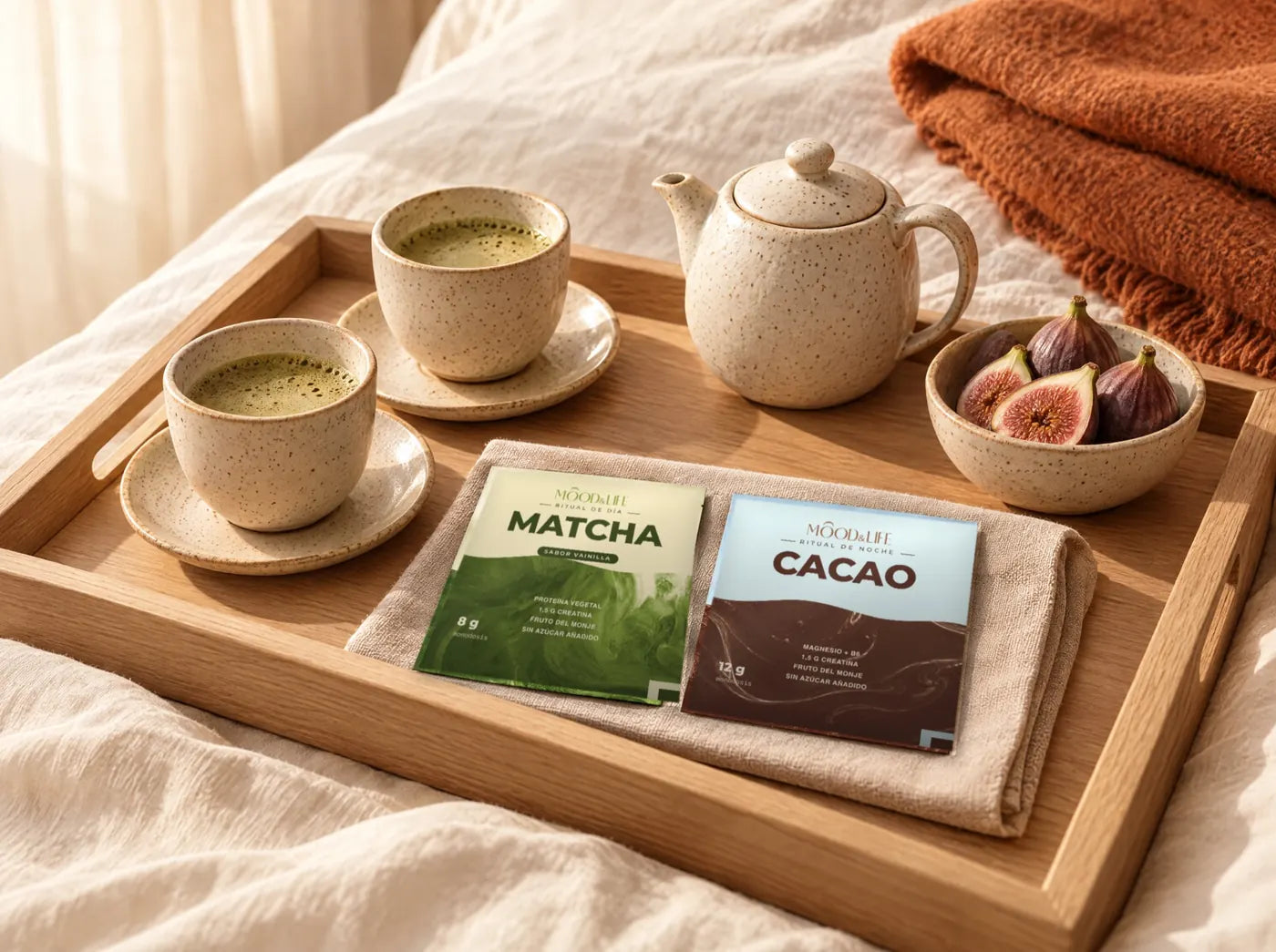 Bandeja de madera sobre una cama con dos tazas de matcha, una tetera y un sobre de cada ritual.