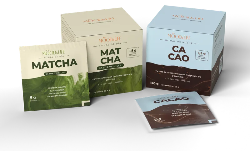 Caja crema y verde de Matcha Ritual y caja azul de Cacao Ritual, con un sobre de cada delante.